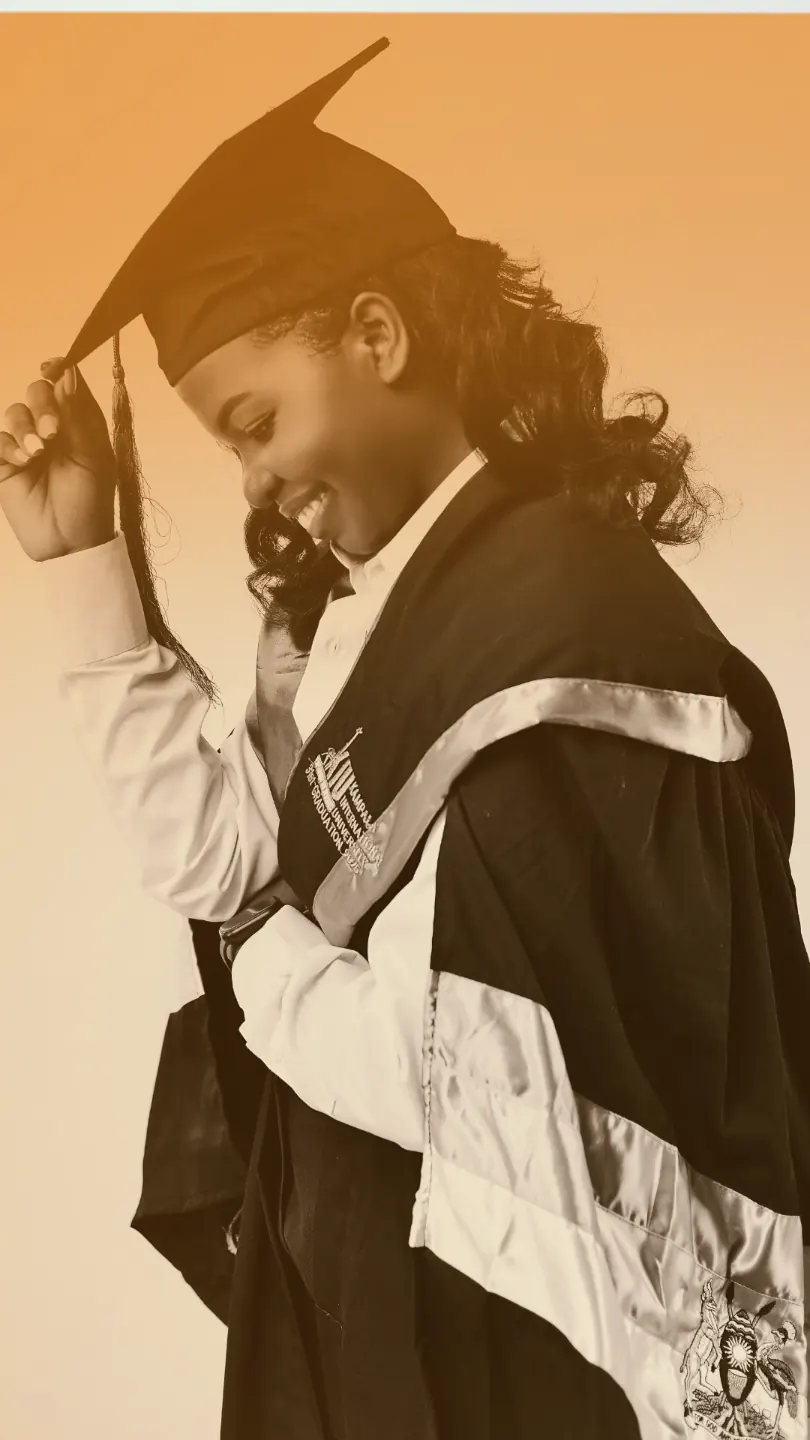 A graduate in cap and gown, smiling